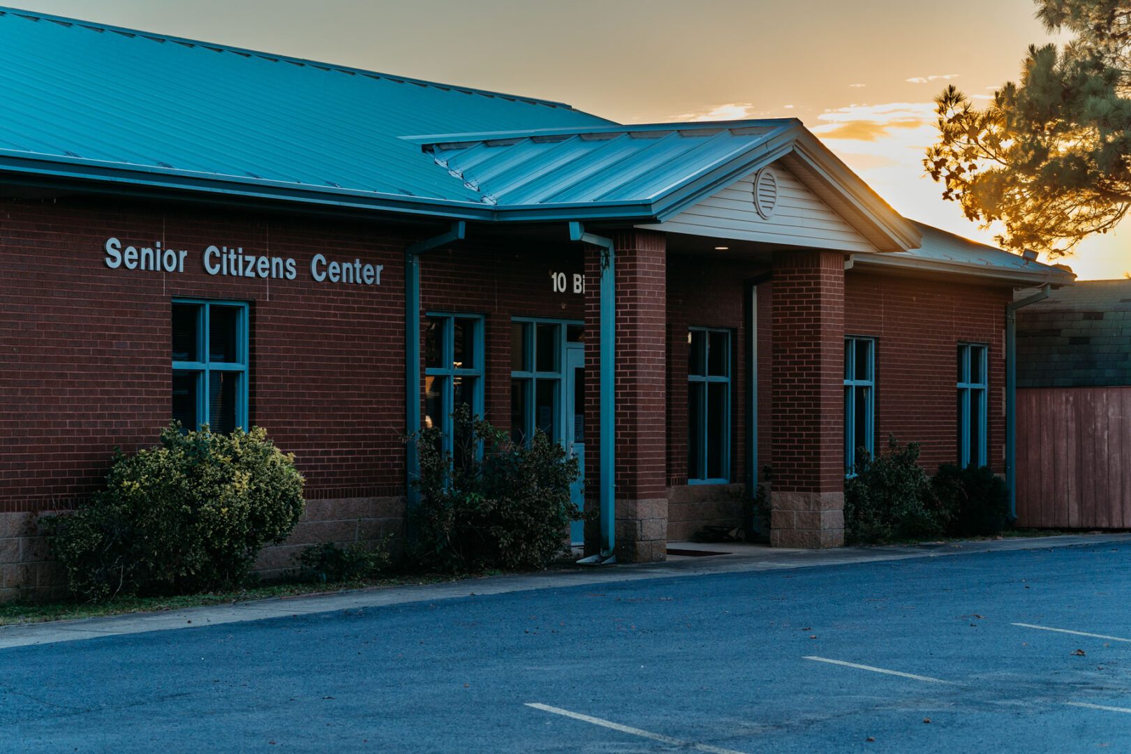 A building with a blue roof and trees in front of it.